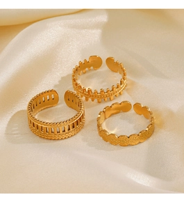 Detailed view of three gold-plated adjustable stainless steel rings on silk fabric