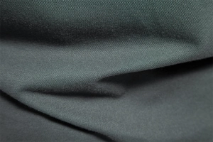Macro shot of dark grey knit fabric texture showing premium piqué weave and material drape