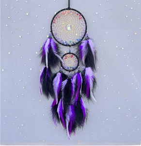 Detail of purple feathers and black double rings dreamcatcher with golden net