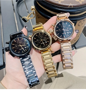 Detailed close-up of three stylish quartz watches with metal straps in black and gold