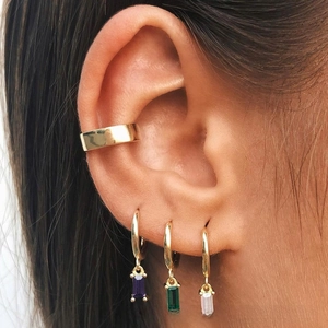 Detail of gold earrings set featuring purple green and white rectangle crystal pendants