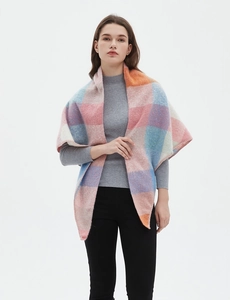 Close-up of multicolored plaid triangle scarf featuring soft knit texture and pastel tones