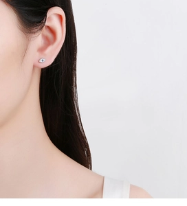 Detail of 925 silver Evil Eye stud earring with blue zircon worn on the earlobe