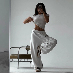 Détail de l'ensemble deux pièces blanc avec t-shirt sport life et pantalon large de sport