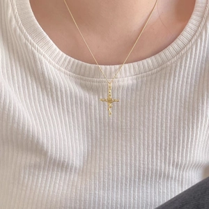 Close-up of 925 silver gold-plated cross necklace with rose pendant on a model