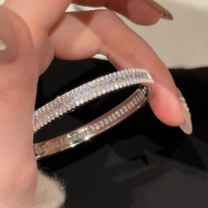 Bracelet jonc argenté élégant avec double rangée de zircons porté au poignet