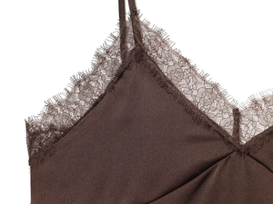 Primo piano dettagliato del tessuto di raso marron scuro con pizzo ciglia sullo scollo a V