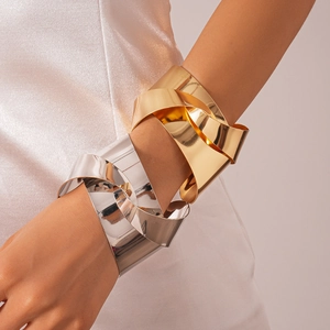 Detail view of bold metallic knotted cuff bracelet in polished gold and silver finishes
