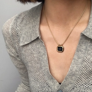 Retro titanium steel gold necklace with square black gemstone pendant on a model