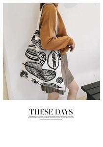 Dettaglio della stampa floreale artistica su borsa tote in tela bianco sporco con foglie