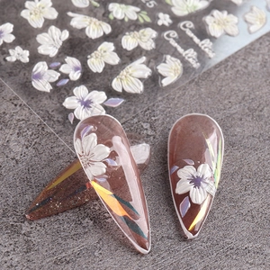 Detailed macro view of 5D-F18 white camellia embossed nail art stickers on fingertips