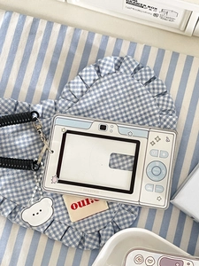 Macro shot of camera-style acrylic card holder with blue bear charm and spring lanyard