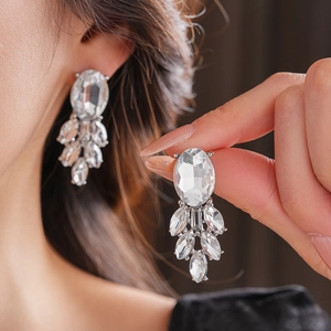 Nahaufnahme eleganter Silber-Ohrringe mit ovalen Kristallen und Strass-Anhänger-Details