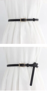 Detail showing a slim black leather belt with golden buckle on a white dress for women