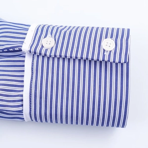 Gros plan des poignets de chemise à rayures avec boutons blancs et coutures précises