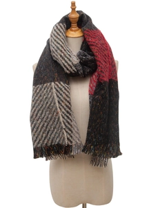 Close-up of winter plaid scarf featuring multicolor herringbone knit and fringe tassels