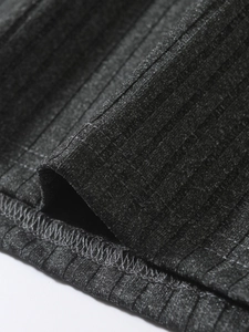 Gros plan détaillé du tissu en maille côtelée gris foncé montrant la texture et l'ourlet