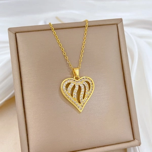Detailed close-up of a gold-plated heart pendant with crystals on a jewelry display