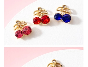 Macro view of cherry-shaped alloy pendants with crystals and golden bows for DIY jewelry