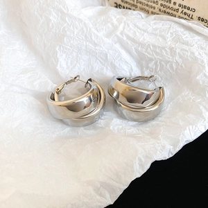 Detail of silver double-layered circular earrings with high-gloss metallic finish