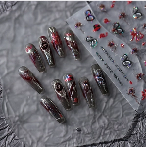 Detail of dark gothic Y2K press-on nails with silver metal lines and red fluid art
