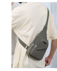Detailed shot of an army green canvas crossbody bag with multiple zippers and adjustable strap