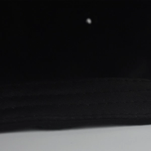 Detailed close-up showing the precise triple stitching on the black cotton baseball cap brim