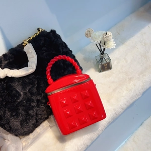 Macro shot of red bucket bag with pyramid texture and twisted handle on white rug