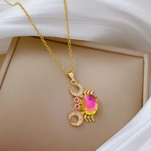 Close-up of gold crab pendant with iridescent gem and crystal-encrusted moon claws