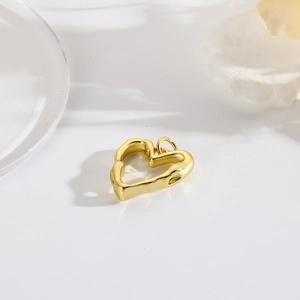 Macro view of a 18k gold plated hollow heart charm with vintage textured surface
