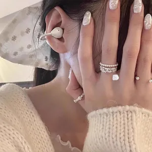 Detail of vintage stackable pearl and silver hollow metal rings for elegant styling