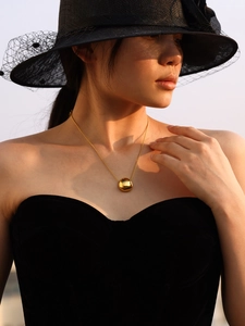 Minimalist 18k gold plated stainless steel bead pendant necklace shown on a model