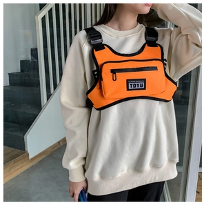 Detail der leuchtend orangefarbenen taktischen Brusttasche mit schwarzen Schnallenriemen
