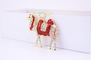 Detailed view of camel keychain with sparkling white and red rhinestones on gold metal