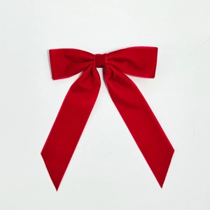 Detailed top view of a large red velvet ribbon bow clip with soft plush texture on white