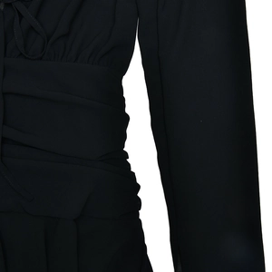 Detail of V-neck chiffon dress showing waist pleats and neck tie-up design in black