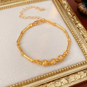 Detailed view of 18K gold plated bamboo link bracelet with zircon inlaid hollow beads