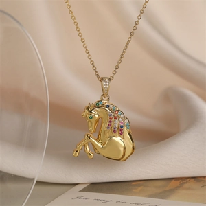 Gros plan du pendentif cheval plaqué or avec zircons colorés sur tissu de soie beige