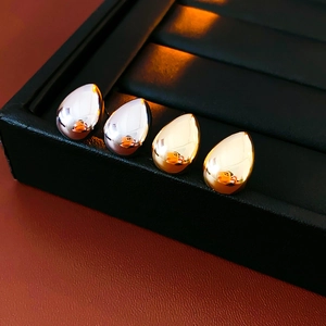 Dettaglio di orecchini a goccia in oro e argento in una scatola di pelle nera di lusso