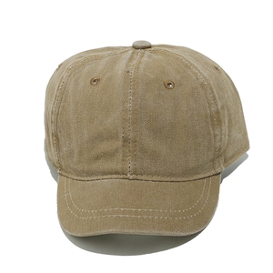 Detailed macro view of khaki washed cotton fabric texture and stitching on the cap brim
