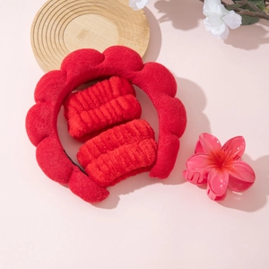 Detailed set of fluffy red skincare headband, plush wristbands, and pink flower hair claw