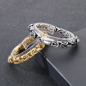 Close-up of gold and silver square king chain bracelets in polished stainless steel