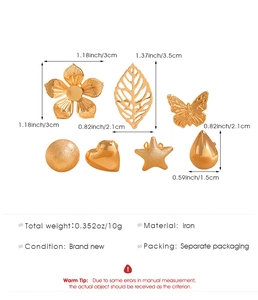 Detailed view of 7 gold iron charms including flower leaf and star shapes with measurements