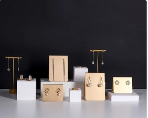 Macro view of gold tassel earrings and pearl jewelry displayed on metal retail stands
