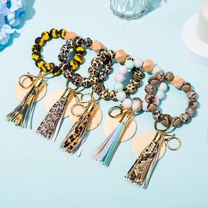 Detail view of silicone bead keychains with animal prints and leather tassels