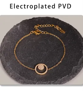 Détail macro du bracelet en acier inoxydable doré avec zircons sur fond de pierre grise