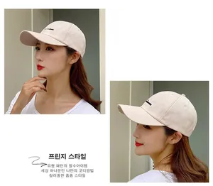 Close-up of beige cotton baseball cap featuring black linear embroidery and side detail