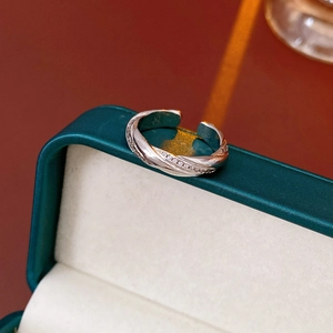 Detail of silver Mobius ring with micro-pave zircons on a dark green jewelry box