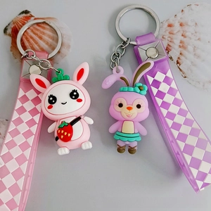 Close-up of cute silicone rabbit pendants with checkered wrist straps and metal keychains