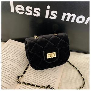 Détail du mini sac en velours noir avec motif matelassé et fermoir rotatif doré